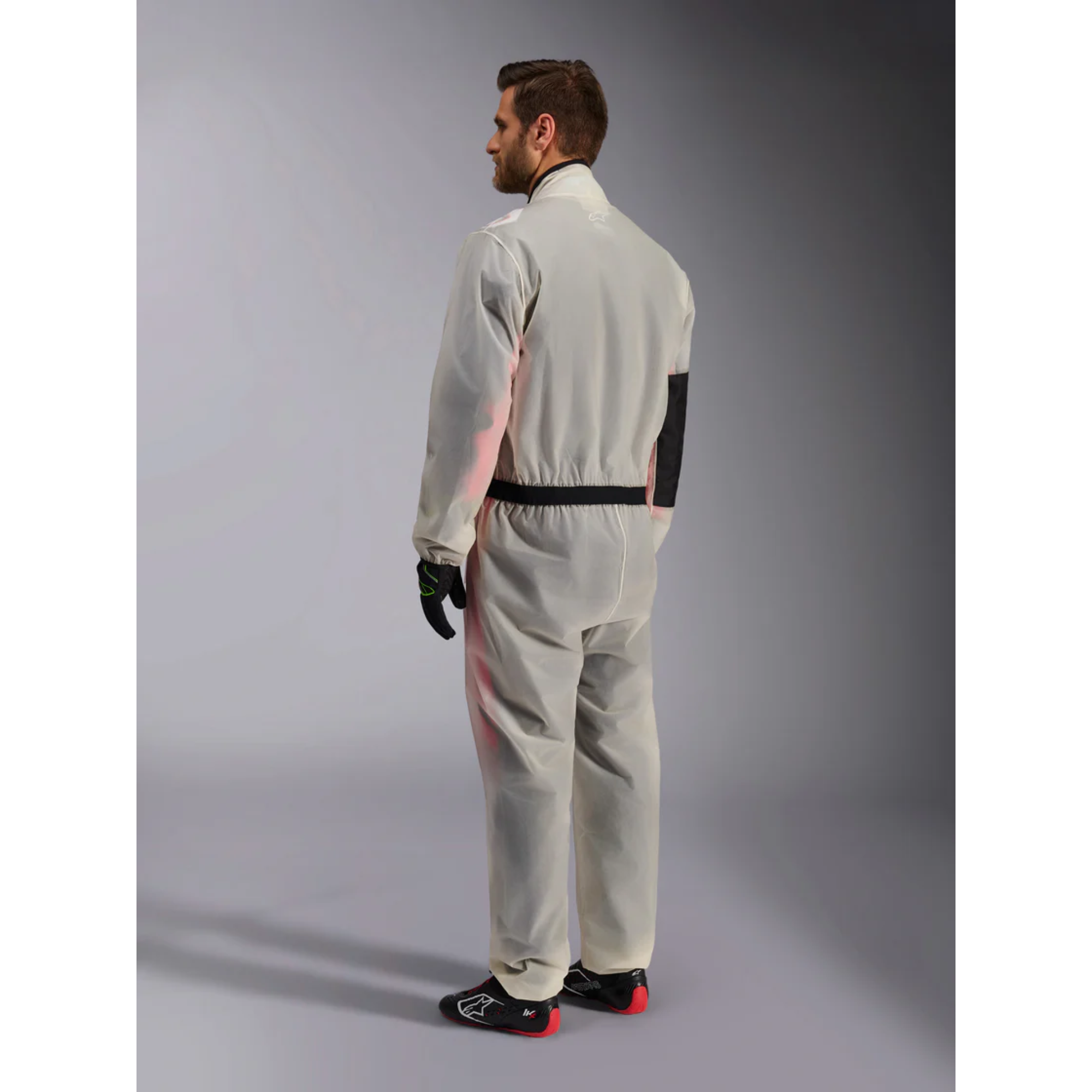 The Alpinestars Kart Rain Suit on a model from the back at an angle.