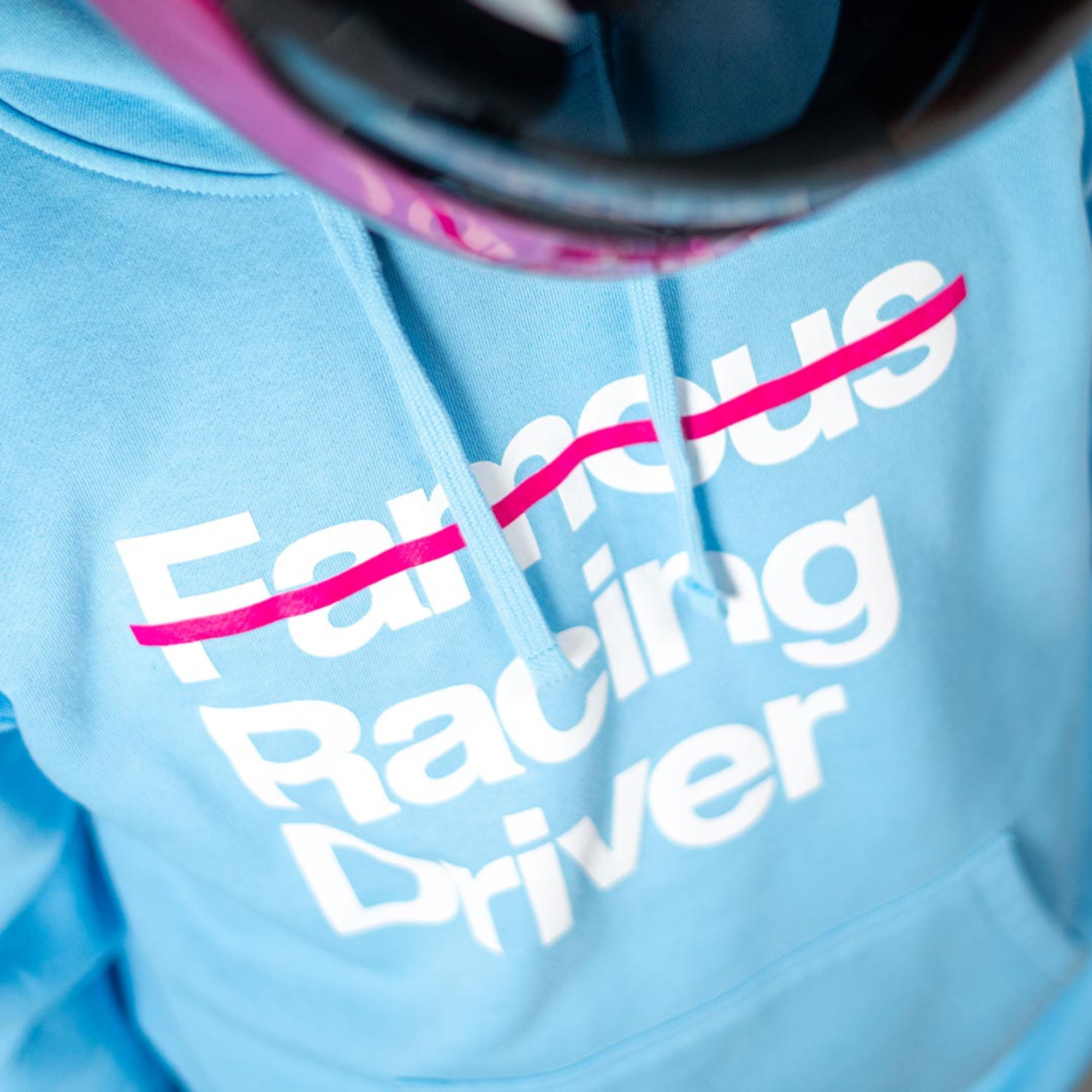 The light blue Not Famous Racing Driver Hoodie from Not Famous Racing Apparel worn by a model close up.