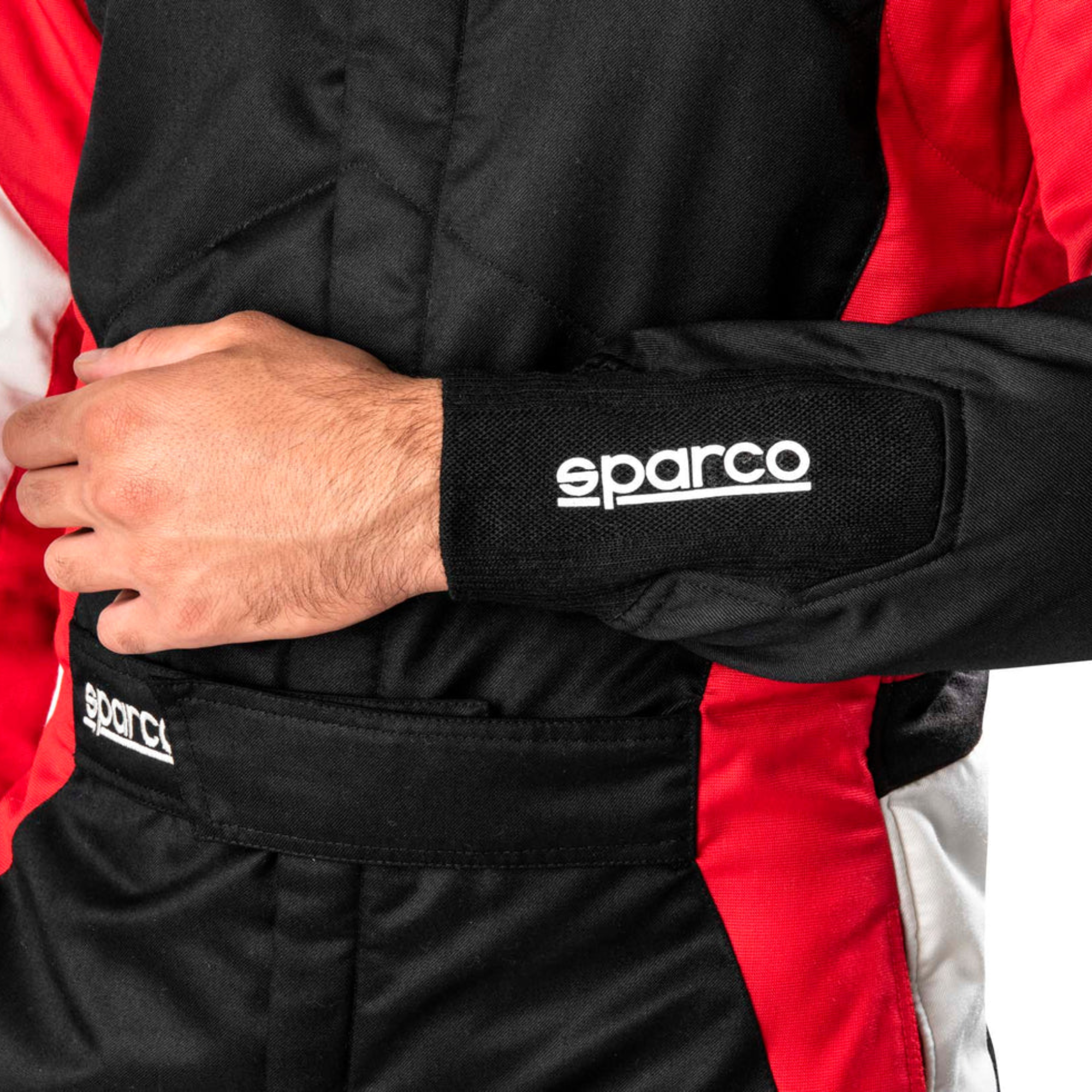 The front of the black, red and white Sparco Competition Racing Suit worn by a model driver close up.