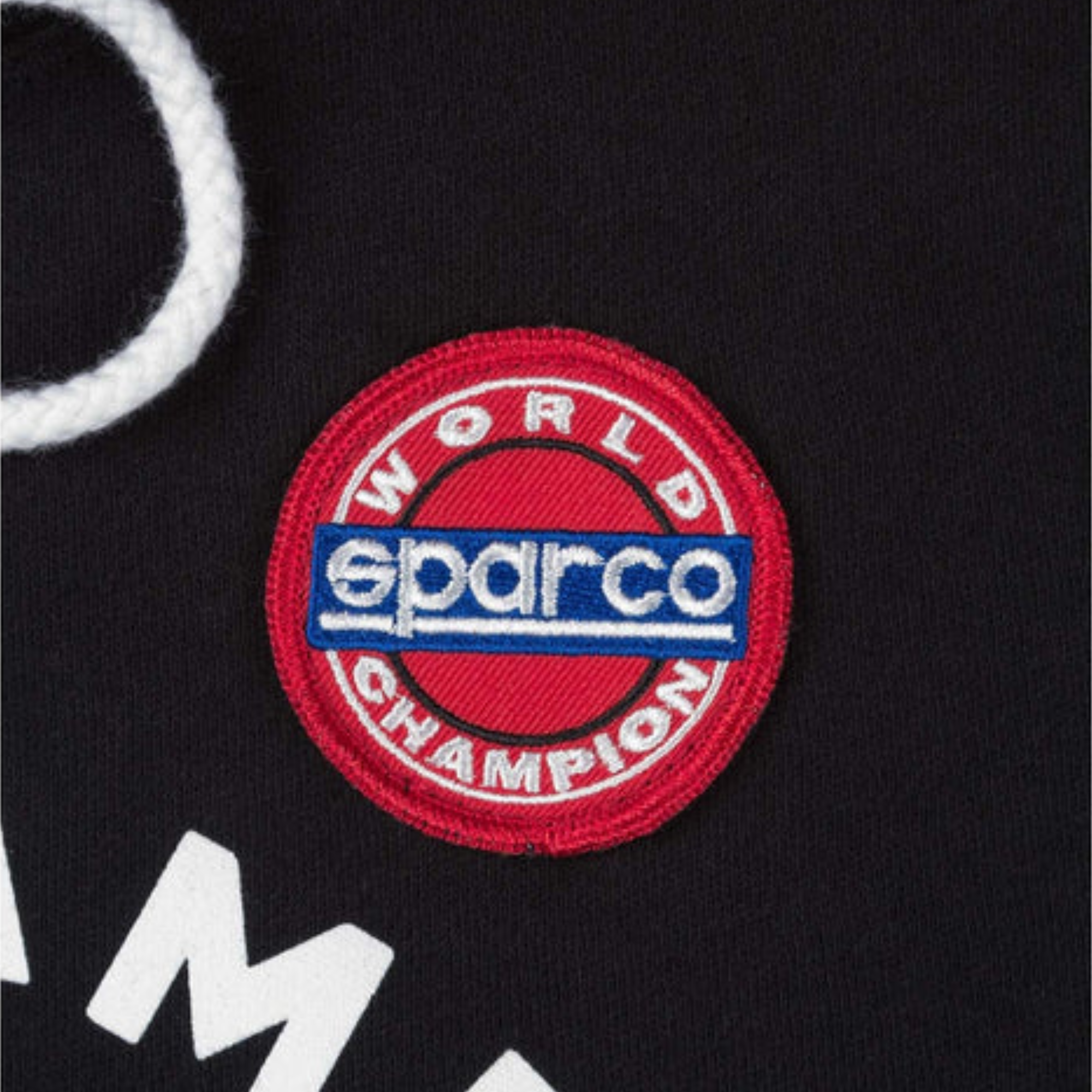 The black Sparco 77 Hooded Sweatshirt from Sparco in a close up on the embroidered patch.