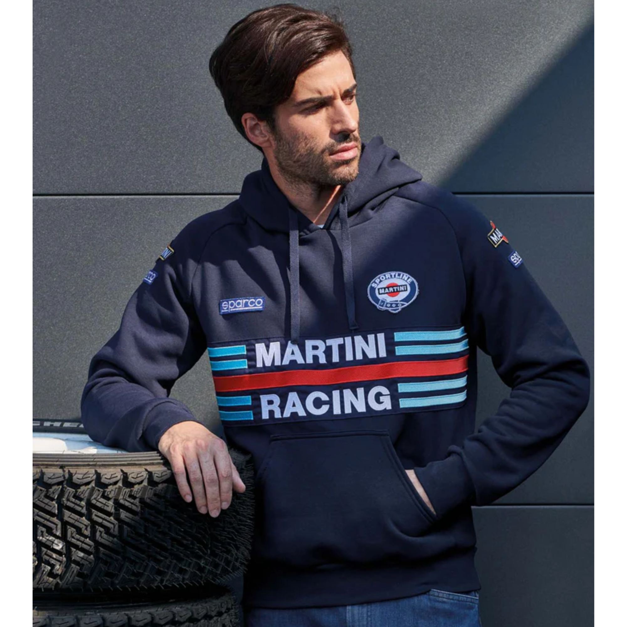 The navy Sparco Martini Racing Hooded Sweatshirt from Sparco in a lifestyle image trackside.
