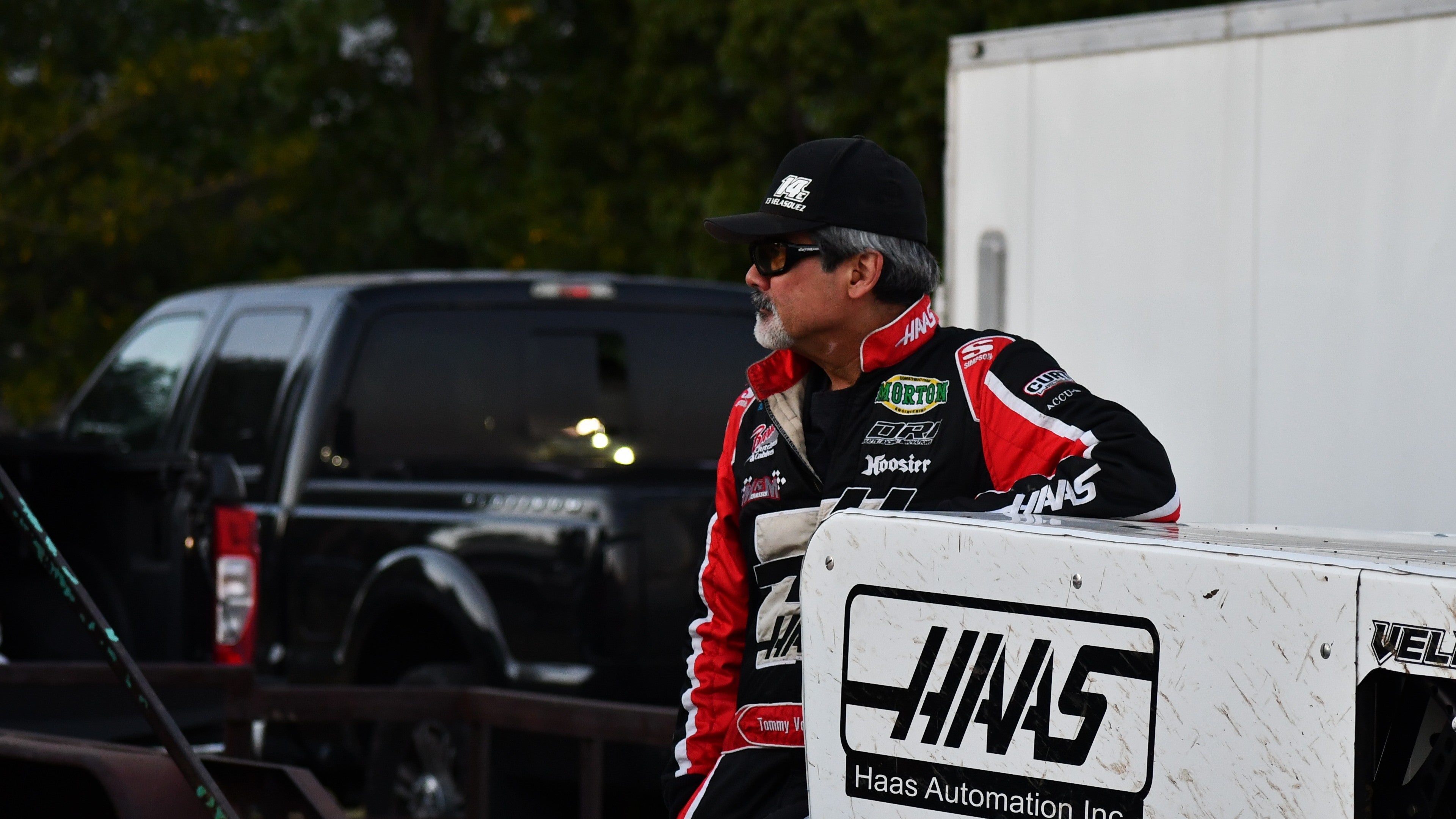 A dirt race driver wearing a Hass Automation Inc branded racing suit at Watsonville Speedway. Driver #14e, Velasquez.