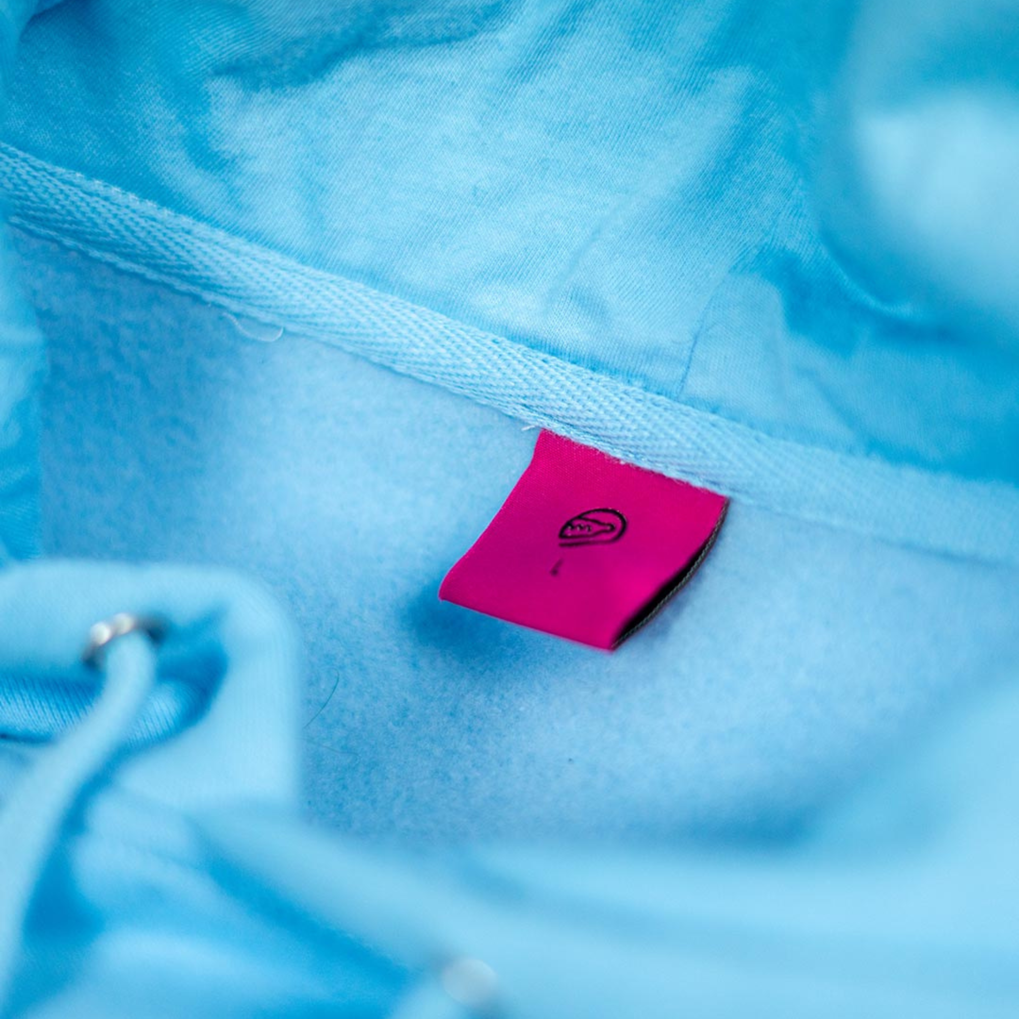 The inside label of the light blue Not Famous Racing Driver Hoodie from Not Famous Racing Apparel.