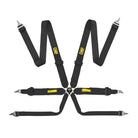 The black FIA 8853-2016 homologated OMP Tecnica 3 Racing Harness, a black 4-point racing harness with silver metal buckles and straps, featuring yellow OMP branding on the shoulder straps and a central black-and-yellow buckle assembly.