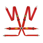 The red FIA 8853-2016 homologated OMP Tecnica 3 Racing Harness, a red four-point racing harness with silver metal snap hooks and black adjustment buckles, featuring yellow and black OCP brand patches on the straps.