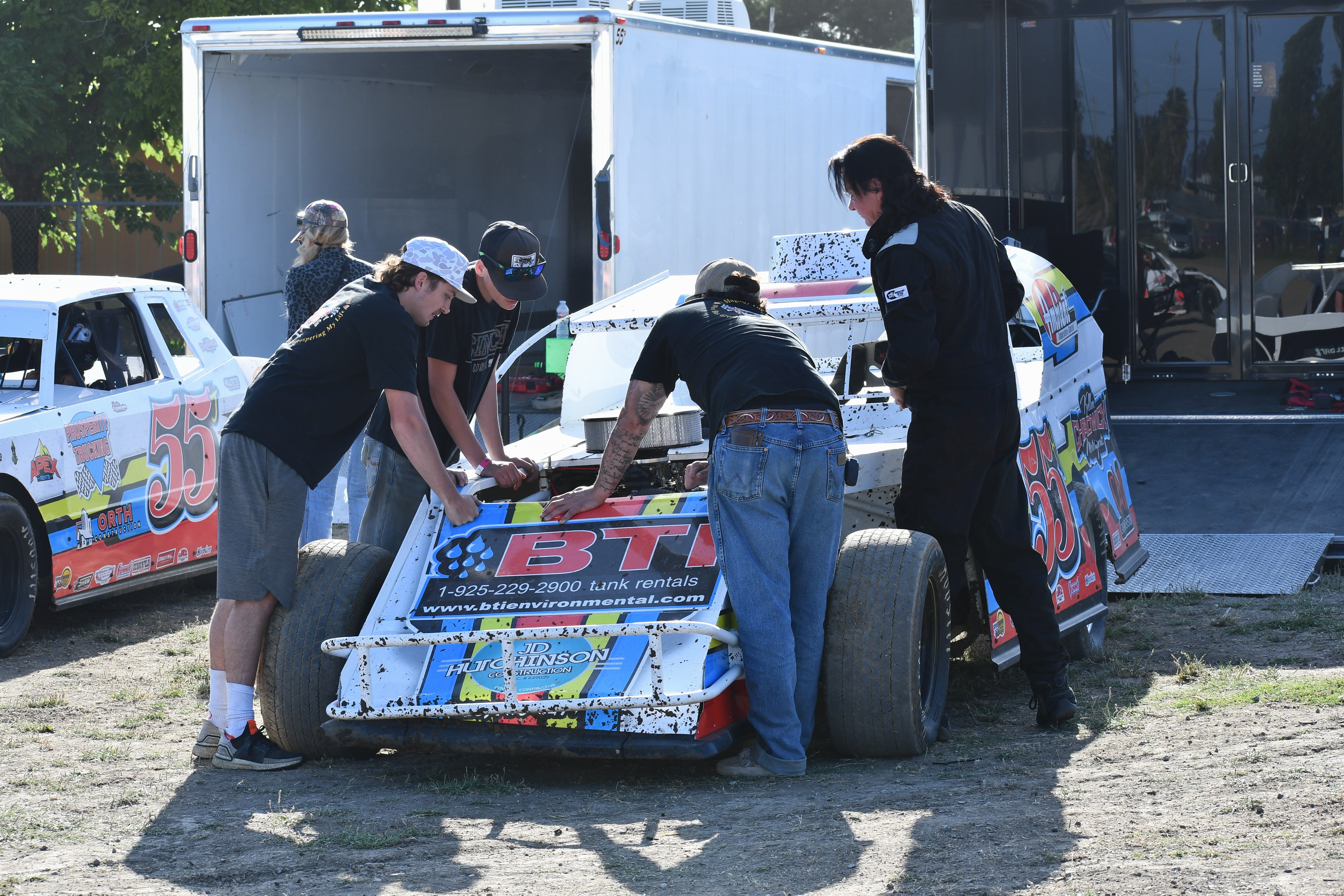 A photo of a small team around a IMCA dirt racing car at Watsonville Speedway, California in June. Credit: Robert Wilson from Everyday Motorsports.