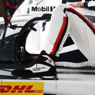 The black and white Stand-21 Porsche Motorsports Daytona3 Racing Shoes from Stand 21 in a trackside photograph.